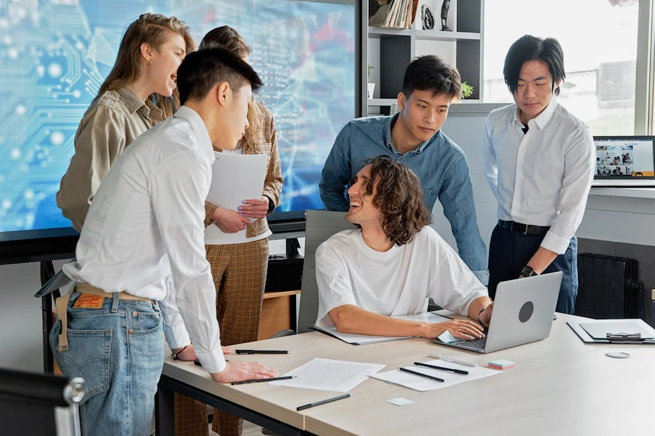 Un team diversificato di Evolve Solutions collabora a un progetto in un ambiente di lavoro luminoso e moderno.